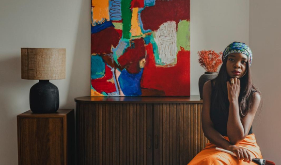 L'artiste pose devant une de ses oeuvres